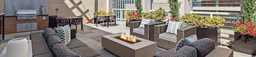 an outdoor patio with couches and chairs and a fire pit