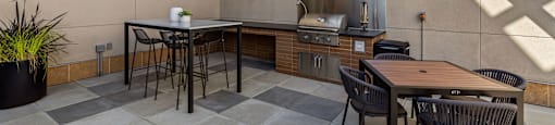 a patio with tables and chairs and a kitchen