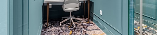 a home office with blue walls and a desk with a chair