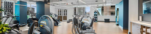 a gym with cardio machines and weights on a wooden floor