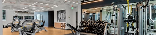 a gym with weights and cardio machines and yoga mats