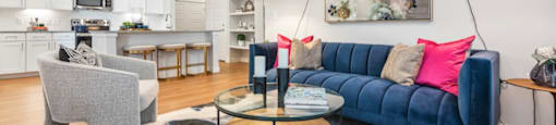 A living room with a blue couch and a grey armchair.