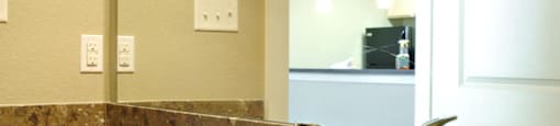 A bathroom with a sink and mirror at Centre Place Apartments, Denton