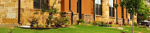 A large building with a brown and tan exterior at Centre Place Apartments, Denton, Texas