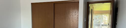 A room with a brown door and a carpeted floor.