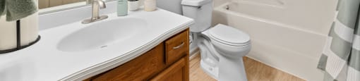 A bathroom with a white sink, toilet, and bathtub.