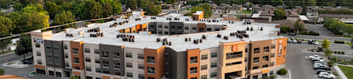 an aerial view of an apartment complex with a sunset in the background at Avenue C Apartments, Montana, 59102