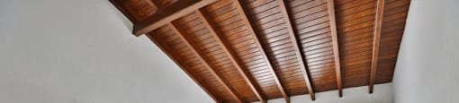 a bedroom with a bed and a wooden ceiling