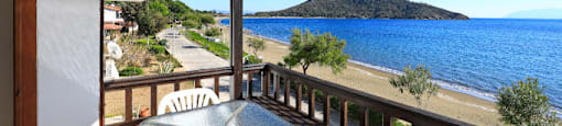 a table and chairs on a balcony overlooking the ocean