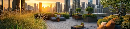 A modern outdoor seating area with a view of the city skyline at sunset.