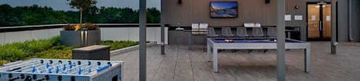 A table tennis table is in the middle of a wooden deck.