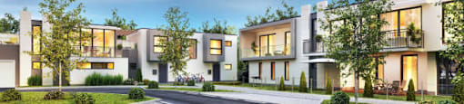 A row of modern houses with trees in front.