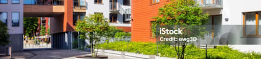 A modern apartment complex with a courtyard and trees.