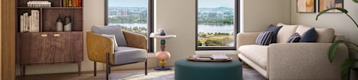 a living room with a couch and two chairs and some windows