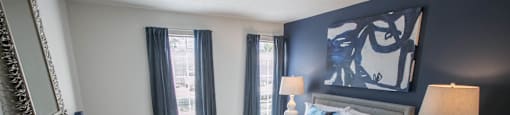 a bedroom with a white bed and blue accent wall carpeted flooring