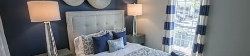 a bedroom with blue walls and a bed with blue and white pillows - blue room