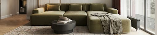 A modern living room with a green sofa and a large window.