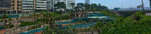 A view of a cityscape with buildings and a tennis court.