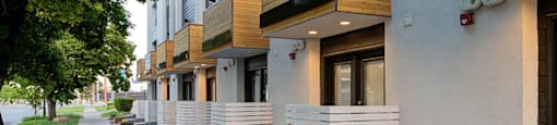 A row of modern houses with white walls and wooden balconies.