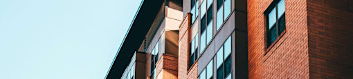 A tall red brick building with many windows.