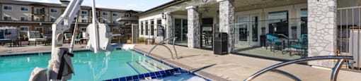 a resort style swimming pool with a building in the background