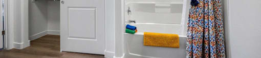 a bathroom with a shower curtain and a white tub