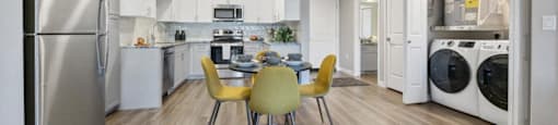 a kitchen with white cabinets and appliances and a table with chairs