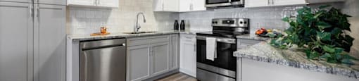 a kitchen with stainless steel appliances and white cabinets