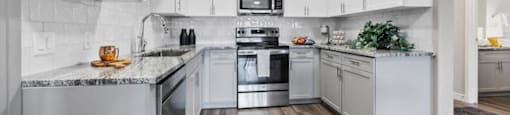 an empty kitchen with white cabinets and stainless steel appliances