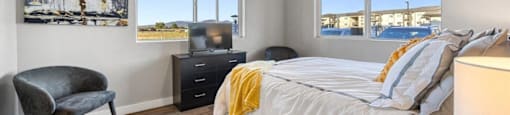 a bedroom with a bed and two windows