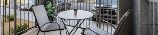 a patio with a table and chairs on a balcony