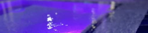 the water in the pool at night is blue and purple