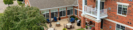 an aerial view of a large brick building with a balcony and a patio with a table and