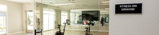 a gym with a sign that reads fitness on demand on a glass wall