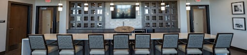 a large meeting room with a large table and chairs in front of a large tv