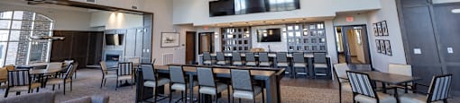 a large dining room with tables and chairs and a bar