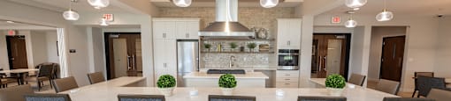 a large kitchen with a large island and chairs in front of a dining table
