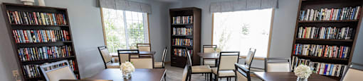 a dining room with a table and chairs and two bookcases with books
