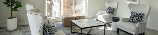 a living room with white furniture and a large window