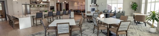 a large dining room with tables and chairs and a kitchen