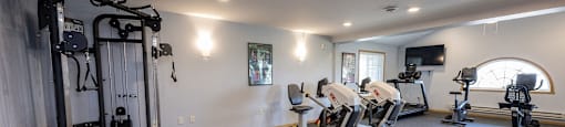a gym with exercise equipment and a tv