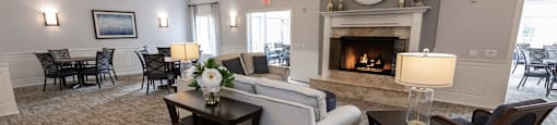 a living room with a fireplace and a dining room in the background