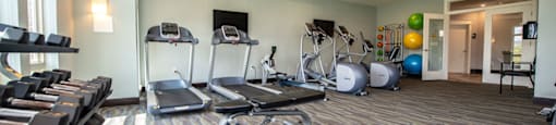 a gym with treadmills and weights on the floor