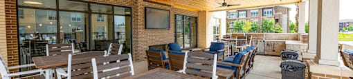 a patio with wooden tables and chairs and a tv