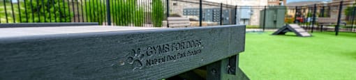 a wooden bench in the grass in front of a building