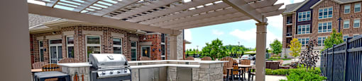 a patio with a grill and a pergola