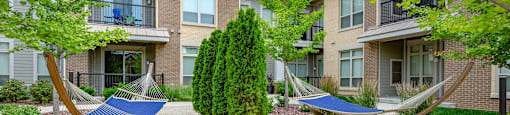 two hammocks in front of an apartment building