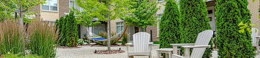 a patio with two chairs and a table in front of a house