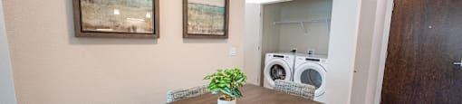 a dining room with a table and chairs and a washing machine in a laundry room