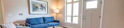 a living room with a blue couch and a coffee table
